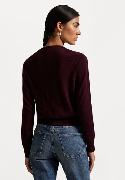 Pull bordeaux à manches longues et encolure ronde, associé à un jean bleu, montrant une texture lisse et une coupe ajustée vue de dos.