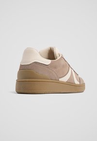 Braune Wildleder- und cremefarbene Leder-Sneaker mit einer strukturierten, tanfarbenen Gummisohle und seitlichen Akzenten, runder Zehenpartie und gepolstertem Kragen für mehr Komfort.