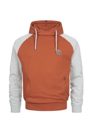 Hettegenser i brent oransje med grå raglanermer, snorer, frontlomme og et teksturert logo-patch på brystet.