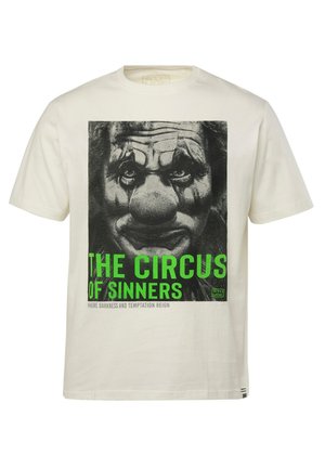 Camiseta de algodón crema con un gráfico de cara de payaso en blanco y negro y texto verde que dice "EL CIRCUS DE LOS PECADORES" debajo.