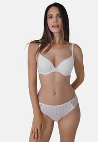 Weißer BH und passender Unterwäsche, mit glatter Stoffoberfläche, gerippten Texturen, Spitzenakzenten und semitransparenten Einsätzen an den Seiten.