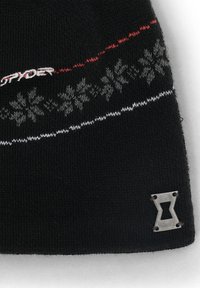 Bonnet en tricot noir avec des coutures blanches et rouges, des motifs de flocons de neige et un accent en métal argenté du logo sur le côté.