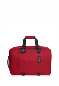 Röd Duffelväska tillverkad av hållbart tyg med svarta handtag, dragkedjestängning och en framsidan med logopatch. Har en rektangulär form och avtagbar axelrem.
