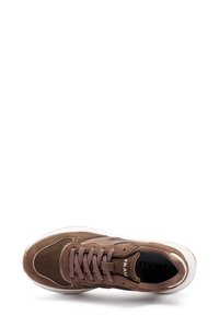 Zapatilla deportiva marrón con parte superior de ante texturizado y corduroy. Cuenta con un diseño de cordones, suela blanca y un logotipo sutil en el costado.