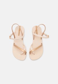 Sandaal met een beige basis, leren gouden banden, gekruist ontwerp, verstelbare enkelriem en een gereviseerd voetbed.