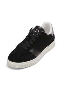 Schwarze Wildleder-Sneaker mit einem glatten Lederakzent, strukturierter weißer Gummisohle und schwarzen Schnürsenkeln, mit einem kleinen Logo auf der Zunge.