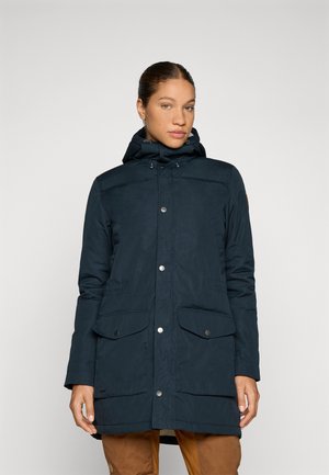 Navy parka met capuchon, voorzien van drukknoopsluitingen, twee voorzakken en een gestructureerde afwerking. Ontworpen voor warmte en functionaliteit.