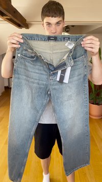 Svetlo modri jeans z ohlapnim krojem, srednje visokim pasom, dvema sprednjima žepoma in priloženimi maloprodajnimi oznakami.