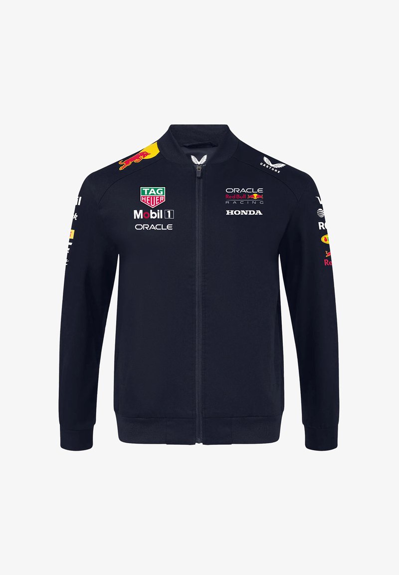 Granatowa kurtka zapinana na zamek błyskawiczny w stylu bomber, z logo na piersi i rękawach, oraz ribbowymi mankietami i dolnym wykończeniem dla lepszego dopasowania.