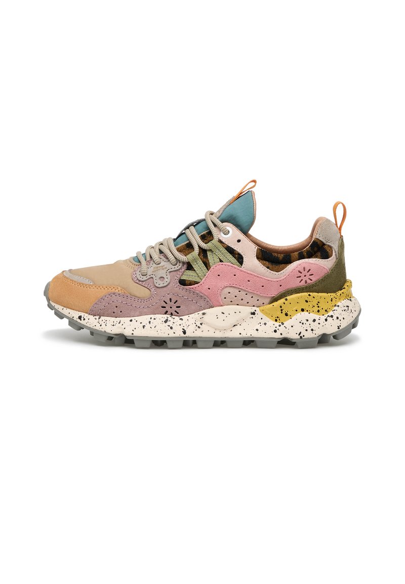 Flerfärgad sneaker med övre del i tan, rosa, grön och blå, blandade material, strukturerade mönster och en prickig vit sula.