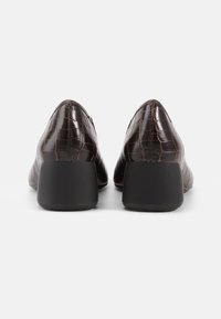 Cizme cu toc din piele texturată, maro, cu un model de crocodil și un toc pătrat negru. Prezintă un vârf ascuțit și un design elegant.