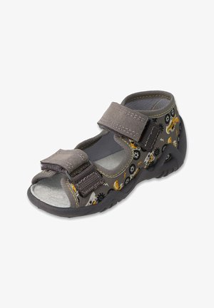 Szare sandały w wzory z rzepami, otwartymi palcami i tekstylnym wierzchem z żółtymi i czarnymi wzorami. Gumowa podeszwa dla lepszej przyczepności.