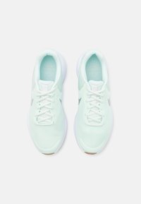 Des chaussures de sport vert menthe clair avec une tige en maille, des lacets blancs et une semelle blanche. Présente un logo argenté subtil sur le côté.