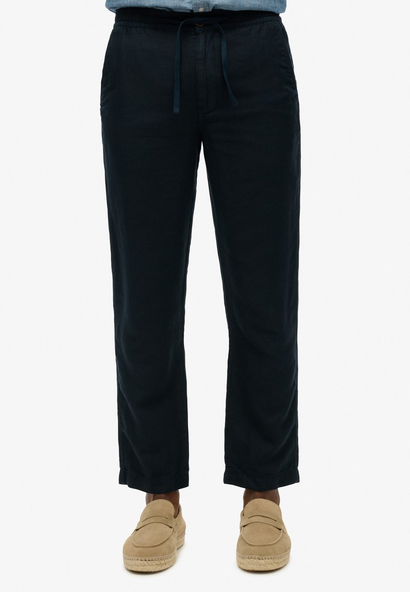 Pantaloni in lino leggeri di colore blu navy, con vita elastica e cordoncino. Design a gamba dritta, con tasche laterali e texture morbida.