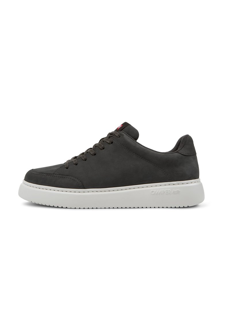 Graue Wildledersneaker mit einer weißen Gummisohle, versehen mit einem Schnürdesign und einem kleinen roten Akzent an der Zunge. Glatte Textur und minimalistische Details.