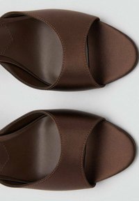 Sandalias deslizantes de satén marrón con punta abierta, diseño de parte superior curva y suela plana. Textura suave con detalles de costura sutiles.