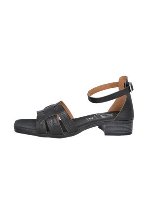 Sandalía de cuero negro con un tacón bajo, que presenta un diseño de tiras trenzadas y una correa para el tobillo con un hebilla de metal. Forro interior suave y parte superior texturizada.