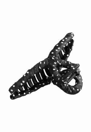 Schwarzer Haarklammer aus Kunststoff, umwickelt mit schwarzem Stoff mit weißen Polka-Dots, zeigt offene Federmechanik und gebogene Zinken.