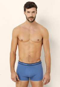 Blue cotton boxer briefs with a smooth texture. Features a black waistband with "yamamay" printed. Form-fitting design, no patterns.