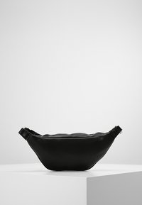 Marsupio nero in ecopelle con forma curva, chiusura con zip e tracolla regolabile. Texture liscia senza motivi o accenti.