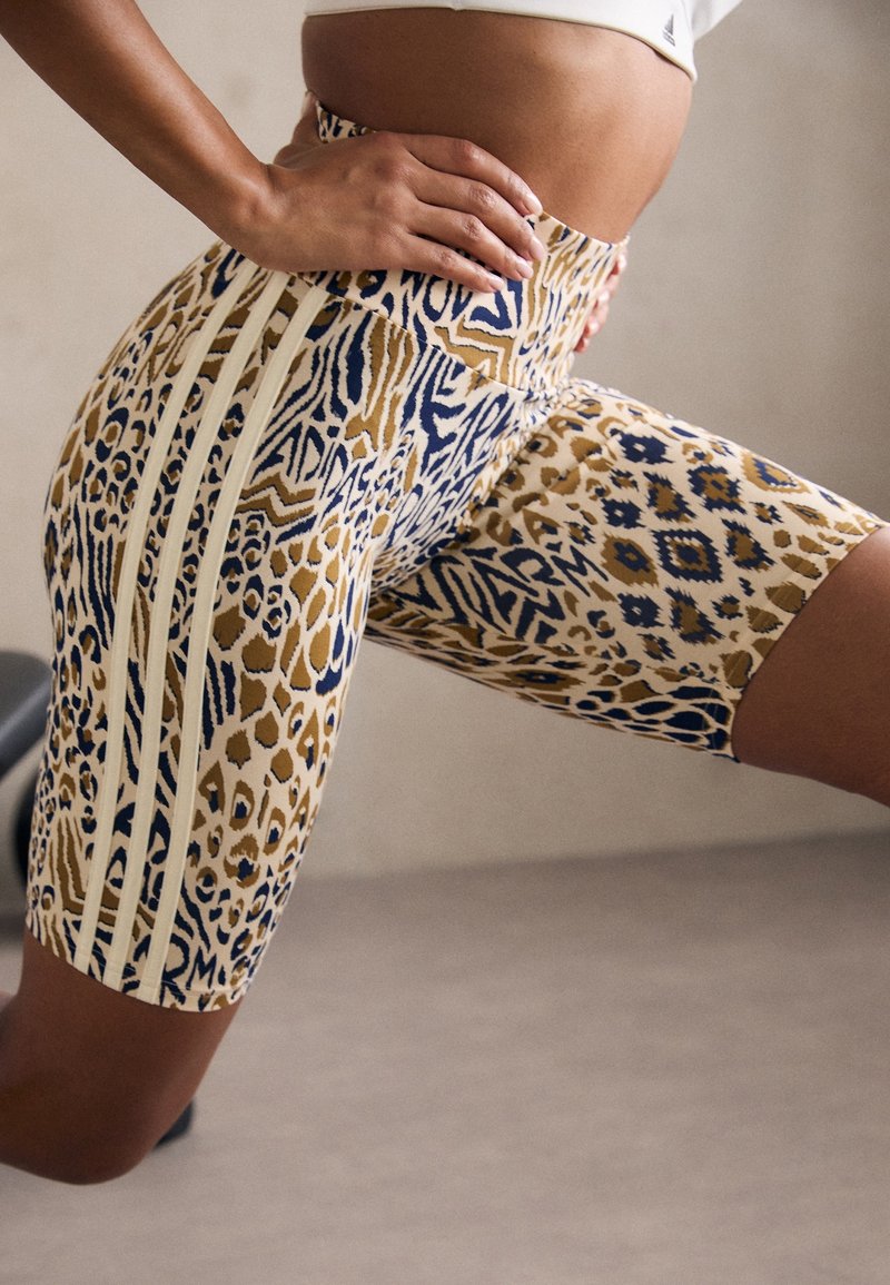 Höga cykelbyxor i leopard- och geometrisk mönster, med en blandning av guld, marinblå och krämfärger samt sidokanter.