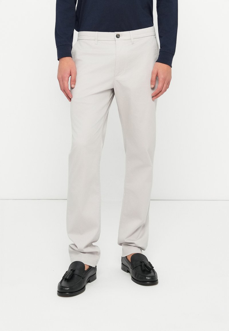 Pantaloni drepți din bumbac gri deschis, cu închidere cu buton și bucle pentru curea. Asortați cu loafers negri, cu detalii de franjuri.