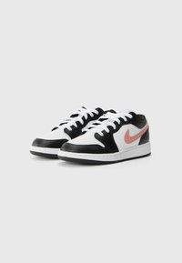 Zemas kedas ar baltu ādas augšdaļu, melnu ādas akcentu un rozā Nike svītru. Iespējas ietver baltas auklas un gumijas zoli.