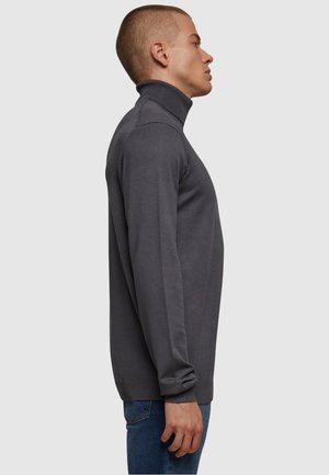 Mørk grå genser med høy hals laget av myk stoff, med slim fit og ribbestrikkede detaljer på kragen og mansjettene.