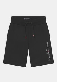 Shorts casual neri con vita a coste, cordino con punte rosso-bianco-blu, tasche laterali e logo verticale di Tommy Hilfiger sulla gamba sinistra.