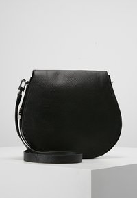 Borsa a tracolla nera in pelle con forma curva, superficie testurizzata, tracolla regolabile e dettagli hardware minimalisti.