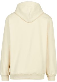 Sweat à capuche couleur crème avec manches longues, poignets en côte, ourlet en côte et une capuche, montré de dos sur fond blanc.