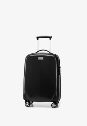 Valise rigide noire avec une surface texturée, poignée argentée et quatre roues. Présente une plaque de logo à l'avant et un design élégant.