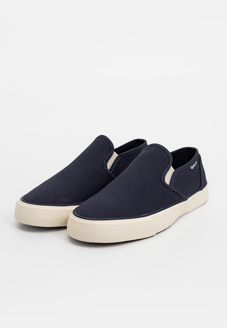 Baskets en toile bleu marine à enfiler avec des semelles en caoutchouc blanc, des panneaux latéraux élastiques et un minimum de branding. Texture lisse avec un design à bout rond.