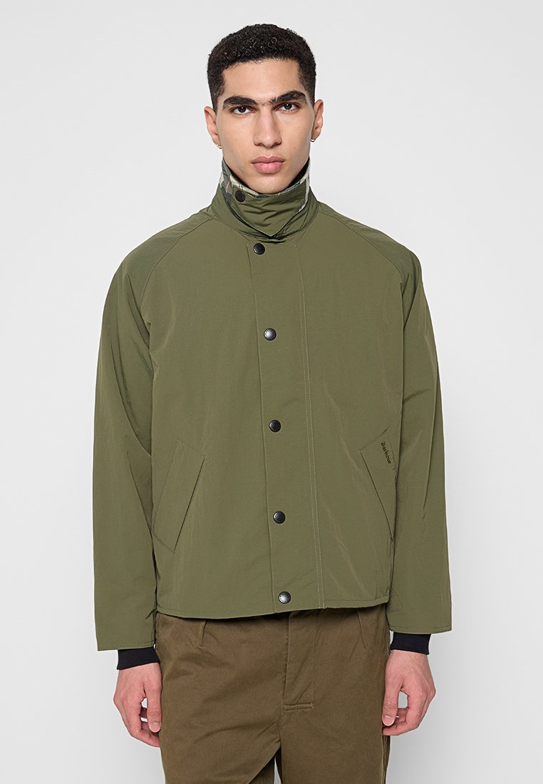 Olijfgroene jas met hoge kraag, drukknoopsluiting en twee zijzakken. Gemaakt van soepel, lichtgewicht stof met een ontspannen pasvorm.