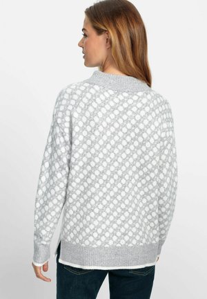Pull gris avec un motif texturé comportant des pois blancs. Manches côtelées et ourlet, fentes sur les côtés pour le confort. Tissu doux.