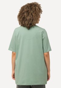 T-shirt oversize verde menta realizzato in morbido cotone, con maniche corte e scollatura rotonda caratterizzata da un discreto dettaglio sulla cucitura posteriore.