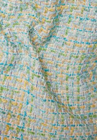 Mehrfarbiger gewebter Stoff mit einer Textur aus blauen, grünen und gelben Fäden, durchzogen von goldenen Strängen für zusätzlichen Glanz.