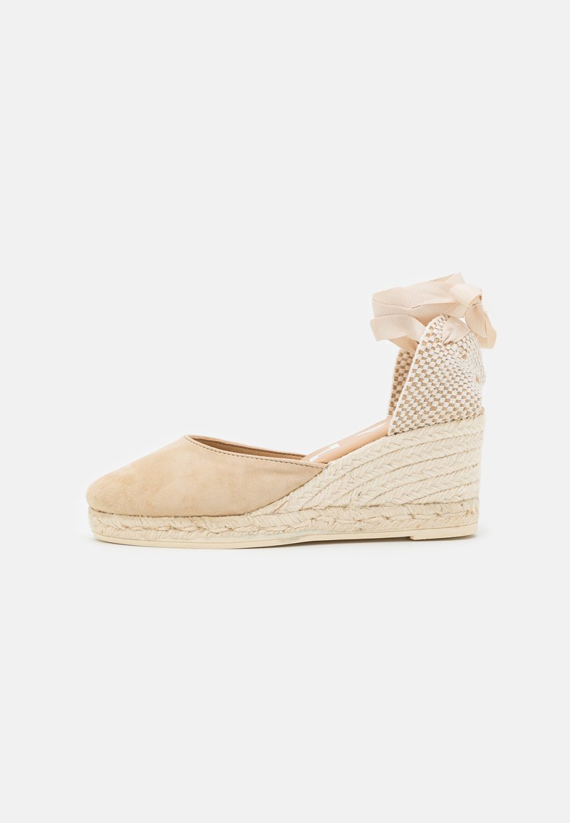 Espadrillas in suede beige con zeppa in juta chiara intrecciata, dotate di un retro in rete e dettaglio in nastro per la chiusura alla caviglia.
