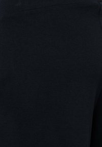 Zwarte stof close-up die een gladde, dicht geweven textuur toont met een subtiel breipatroon en lichte rek.