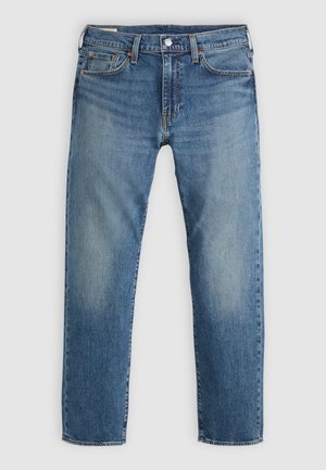 Jeans de mezclilla azul con un corte recto, que presentan un desgaste en los muslos, cinco bolsillos y un cierre de botón plateado en la cintura.