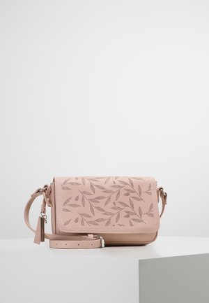 Lyserød crossbody taske med justerbar rem, perforeret bladmønster på klappen og en lille hængende tag på en hvid overflade.