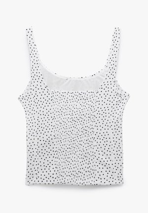 Top sin mangas blanco con lunares negros, con una textura de tela suave y un escote fruncido para añadir detalle.