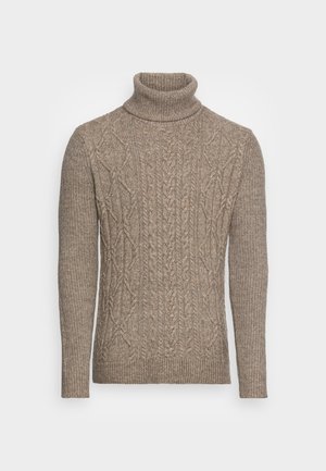 Beige neulepusero, jossa on tekstuurisia palmikkokuvioita, korkeat hihansuut ja helma. Kankaan pinta näyttää pehmeältä ja lämpimältä.