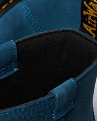 Interior de bota de couro turquesa com acabamento texturizado, forro preto e costura azul em contraste. Apresenta uma robusta alça de tecido.