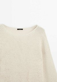 Let, cremefarvet sweater med åben mesh-strikmønster, rund halsudskæring og løs pasform. Fremstillet af åndbart materiale.