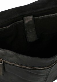Zwarte leren handtas met een gladde oppervlakte, voorzien van een ritssluiting en een binnenvoering van suède. Het interieur heeft een klein vakje.