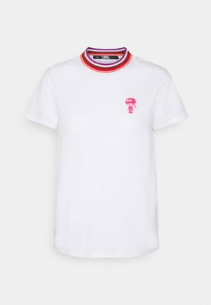 Biała koszulka z krótkim rękawem z prążkowanym kołnierzykiem w czerwone, fioletowe i różowe paski, z małą różową postacią z kreskówki na lewej piersi.