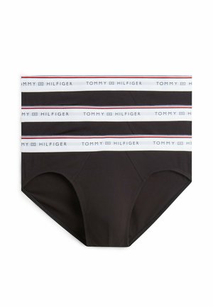 Tre sorte herreunderbukser med hvide elastiske linninger i taljen, hver med teksten "Tommy Hilfiger" og et lille flaglogo i blå, rød og hvid.