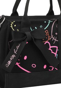 Borsa tote nera in canvas con facce colorate di Hello Kitty e un accento di fiocco rosa. Presenta manici resistenti e un'etichetta con logo "Hello Kitty."