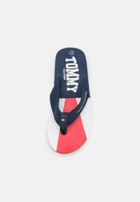 Infradito blu navy con accenti rossi e bianchi. Presenta cinturini in tessuto e un logo sulla soletta. Design con suola piatta.